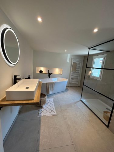 Luxuriöses Badezimmer mit freistehender Badewanne, begehbarer Dusche und modernem Waschtisch