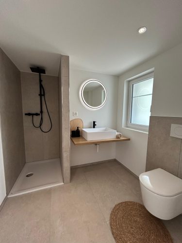 Modernes Badezimmer mit begehbarer Dusche und stilvollem Waschbereich